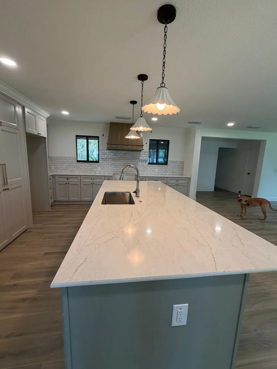 Large white island with a single level top and an undermount sink