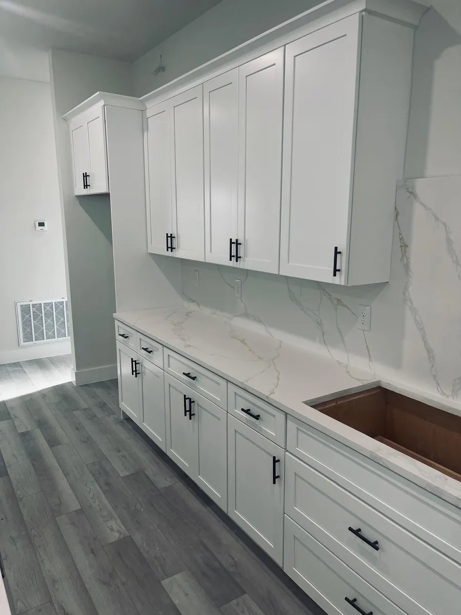 Kitchen run with a stone slab backsplash and a copper farmhouse sink