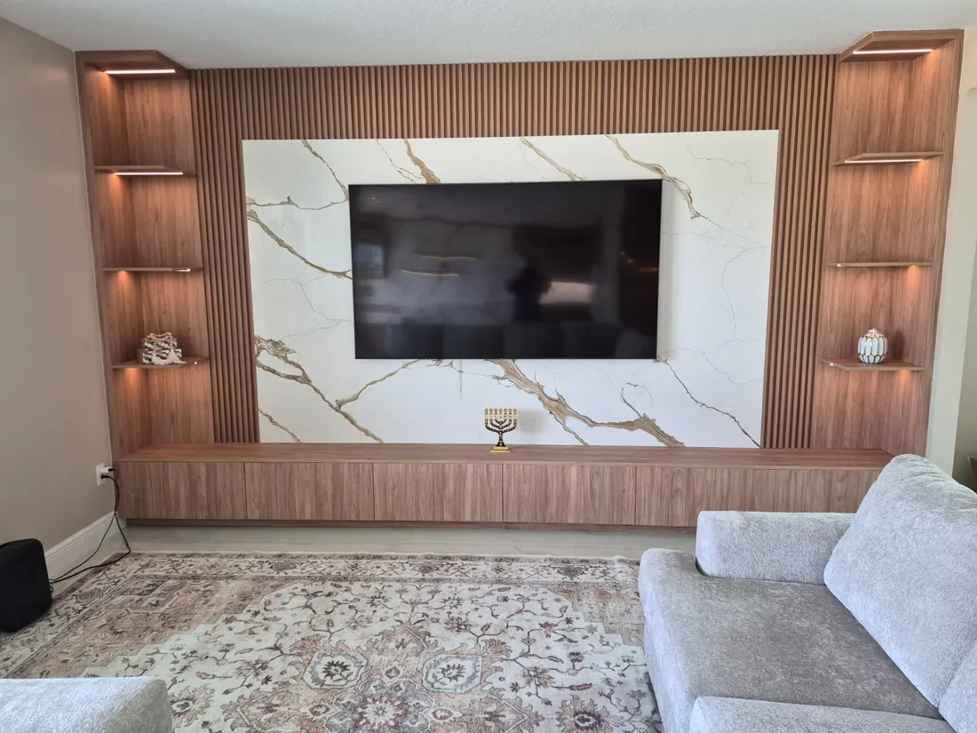 Living room feature wall faced with a book matched stone panel