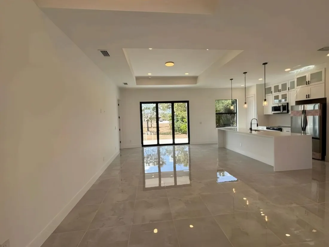 Open kitchen with a long island and a stone backsplash running to the cabinets