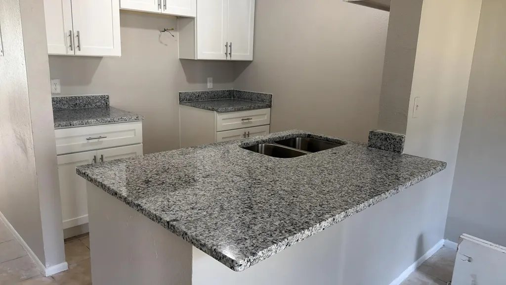 Granite countertop and breakfast bar in a finished kitchen
