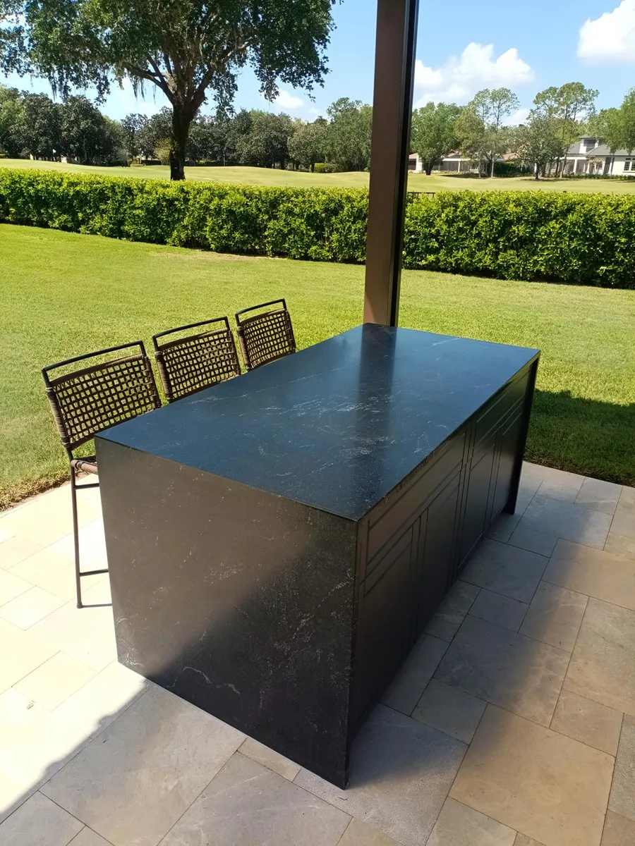 Dark stone outdoor island on a patio with a covered pergola