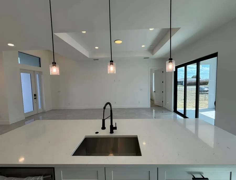 Kitchen island with a white stone top and an undermount sink